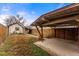 Backyard featuring a covered parking area, brown fence, and portion of home, with grass at 2515 Ames St, Edgewater, CO 80214