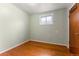 Bedroom with wooden floors and light green painted walls, including a small window at 2515 Ames St, Edgewater, CO 80214