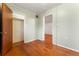 Bedroom with wooden floors and light green painted walls and walk-in closet with wood door at 2515 Ames St, Edgewater, CO 80214