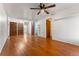 Open-concept living room with wood floors, ceiling fan, and white walls at 2515 Ames St, Edgewater, CO 80214