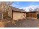 Tan shed with dark brown trim and a single door sits near a brown-stained wooden fence at 2515 Ames St, Edgewater, CO 80214