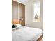 Modern bedroom featuring wood paneled accent wall, contemporary lighting, and a large window at 9185 W Eaton St, Westminster, CO 80031