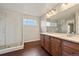 Bathroom featuring a double sink vanity, large mirror, and glass shower enclosure at 11704 Hale Ct, Parker, CO 80138