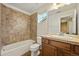 Full bathroom with tiled shower over tub, large mirror, and wooden vanity at 11704 Hale Ct, Parker, CO 80138