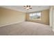 Spacious bedroom with neutral carpet, a ceiling fan, and a large window overlooking the front yard at 11704 Hale Ct, Parker, CO 80138