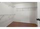 Empty walk-in closet features wire shelving, carpeted floors, and access to bathroom at 11704 Hale Ct, Parker, CO 80138