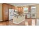 Spacious kitchen featuring a center island, wood cabinets, stainless steel appliances, and wood floors at 11704 Hale Ct, Parker, CO 80138
