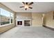 Bright living room featuring a cozy fireplace, neutral carpet, and a large window at 11704 Hale Ct, Parker, CO 80138