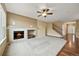 Cozy living room featuring a fireplace, ceiling fan, neutral carpet, and staircase access at 11704 Hale Ct, Parker, CO 80138