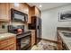 Efficient kitchen with black appliances and wood cabinets, complete with granite counters at 34 Highfield Trl # 112, Breckenridge, CO 80424