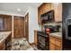 Kitchen with wood cabinets, granite counters and tiled floors, complete with black appliances at 34 Highfield Trl # 112, Breckenridge, CO 80424