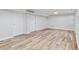 Spacious basement area featuring modern wood-look flooring and neutral walls at 4003 Federal Blvd, Denver, CO 80211