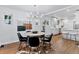 Open concept dining room with modern chandelier, table with black chairs, and wood floors at 4003 Federal Blvd, Denver, CO 80211