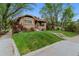 Charming brick home with a well-manicured lawn and mature trees near a concrete sidewalk at 4003 Federal Blvd, Denver, CO 80211