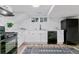 Updated kitchen featuring black appliances, white cabinets and countertops with a modern rug at 4003 Federal Blvd, Denver, CO 80211