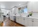 Modern kitchen boasts white cabinets, stainless appliances, and large window at 4003 Federal Blvd, Denver, CO 80211