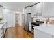 Modern kitchen featuring stainless steel appliances, white cabinets, and hardwood floors at 4003 Federal Blvd, Denver, CO 80211