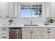 Close-up of a kitchen sink with modern fixtures, white countertops, and a bright window at 4003 Federal Blvd, Denver, CO 80211