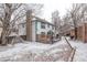 Home exterior featuring a spacious deck area with a privacy fence in a snow covered backyard at 12107 E Vassar Dr, Aurora, CO 80014