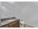 A bright bathroom with granite countertop vanity and standard toilet at 12107 E Vassar Dr, Aurora, CO 80014