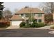Charming two-story brick home with green shutters, a large garage, and a well-maintained lawn at 12107 E Vassar Dr, Aurora, CO 80014