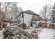Exterior shot of the home's backyard with a fire pit, deck, and storage against a snowy backdrop at 12107 E Vassar Dr, Aurora, CO 80014