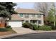 Inviting two-story brick home with a well-manicured front yard and an attached two-car garage at 12107 E Vassar Dr, Aurora, CO 80014