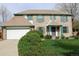 Classic brick home with green trim, an attached garage, and established landscaping at 12107 E Vassar Dr, Aurora, CO 80014