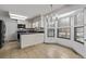 Eat-in kitchen with tile floors and granite counters beneath traditional chandelier near bay window at 12107 E Vassar Dr, Aurora, CO 80014