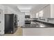 Well-lit kitchen with black appliances, granite countertops and tile flooring at 12107 E Vassar Dr, Aurora, CO 80014
