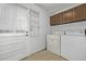 A practical laundry room with washer, dryer, shelving, and access to the backyard at 12107 E Vassar Dr, Aurora, CO 80014
