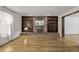 Cozy living room featuring a brick fireplace with built-in shelves and wood flooring at 12107 E Vassar Dr, Aurora, CO 80014