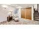 Basement room with neutral decor featuring a cozy sitting area, closet, and stairway access at 1141 Beech St, Fort Lupton, CO 80621
