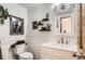 Cozy bathroom featuring a decorative mirror and wainscoting, complemented by stylish wall accents and a plant at 1141 Beech St, Fort Lupton, CO 80621