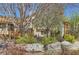 Charming home featuring a meticulously landscaped front yard with mature trees and decorative rock features at 1141 Beech St, Fort Lupton, CO 80621