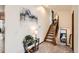 Bright hallway with a decorative console table, staircase, and lovely artwork at 1141 Beech St, Fort Lupton, CO 80621