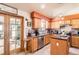 Well-appointed kitchen featuring warm wood cabinetry, granite countertops, stainless steel appliances, and tiled floor at 1141 Beech St, Fort Lupton, CO 80621