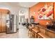 Well-designed kitchen and bar area open to the home's entryway, with stainless steel refrigerator and tile flooring at 1141 Beech St, Fort Lupton, CO 80621