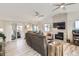 Bright living room with stone fireplace, multiple ceiling fans, sliding glass door, and wood-look flooring at 1141 Beech St, Fort Lupton, CO 80621
