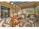 Relaxing outdoor space under a wooden pergola, furnished with comfortable seating and decorative floral accents at 1141 Beech St, Fort Lupton, CO 80621