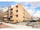 Multi-story brick apartment building with red awnings, ample parking, and a well-maintained exterior at 1243 N Washington St # 108, Denver, CO 80203