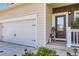 Close up of a home's front door, garage and covered porch with a decorative wreath and tidy landscaping at 1063 Gianna Ave, Fort Lupton, CO 80621