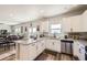 Open kitchen with white cabinets, granite counters, stainless appliances, connecting to a dining area at 1063 Gianna Ave, Fort Lupton, CO 80621