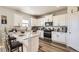 Modern kitchen with white cabinets, granite countertops, stainless steel appliances, and wooden floor at 1063 Gianna Ave, Fort Lupton, CO 80621