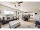 Open-concept living area with a ceiling fan, and dining area with natural light at 1063 Gianna Ave, Fort Lupton, CO 80621