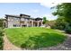 Expansive green backyard with a stone and wood paneled home in the background at 12775 Horizon Trl, Castle Pines, CO 80108