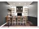 Modern basement bar with open shelves, decorative lighting, and seating at 12775 Horizon Trl, Castle Pines, CO 80108