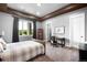 Neutral bedroom featuring a large window, tray ceiling detail, and work space at 12775 Horizon Trl, Castle Pines, CO 80108