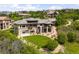 Back exterior of an impressive home, showcasing a manicured lawn and hillside views at 12775 Horizon Trl, Castle Pines, CO 80108