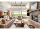 Bright living room featuring a stone fireplace, vaulted ceilings, and scenic outdoor views at 12775 Horizon Trl, Castle Pines, CO 80108